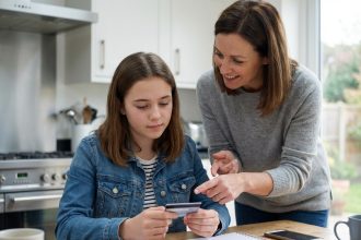 Jeune fille de 16 ans tenant sa première carte bancaire